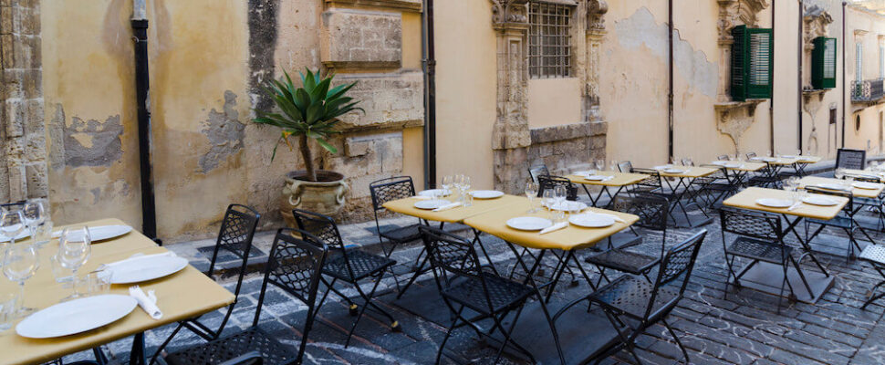Outdoor café with empty tables and chairs.